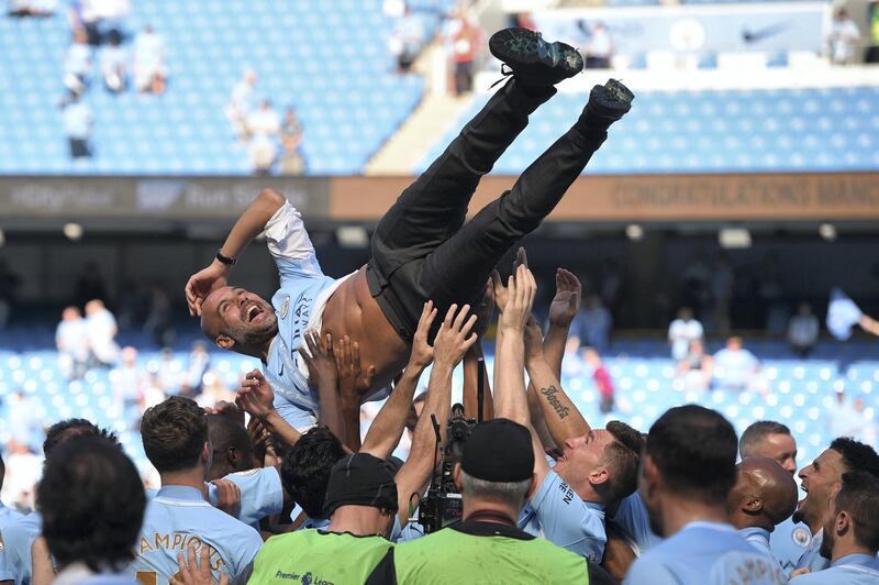 Manchester City's Spanish manager Pep Guardiola is tossed by Manchester City players during the trophy ceremony after the English Premier League football match between Manchester City and Huddersfield Town at the Etihad Stadium in Manchester, north west England, on May 6, 2018. (Photo by Oli SCARFF / AFP) / RESTRICTED TO EDITORIAL USE. No use with unauthorized audio, video, data, fixture lists, club/league logos or 'live' services. Online in-match use limited to 75 images, no video emulation. No use in betting, games or single club/league/player publications. / 