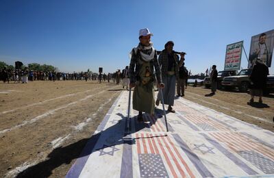 Tribesmen loyal to the Houthis step on US and Israeli flags during a protest on the outskirts of Sanaa on Thursday. EPA