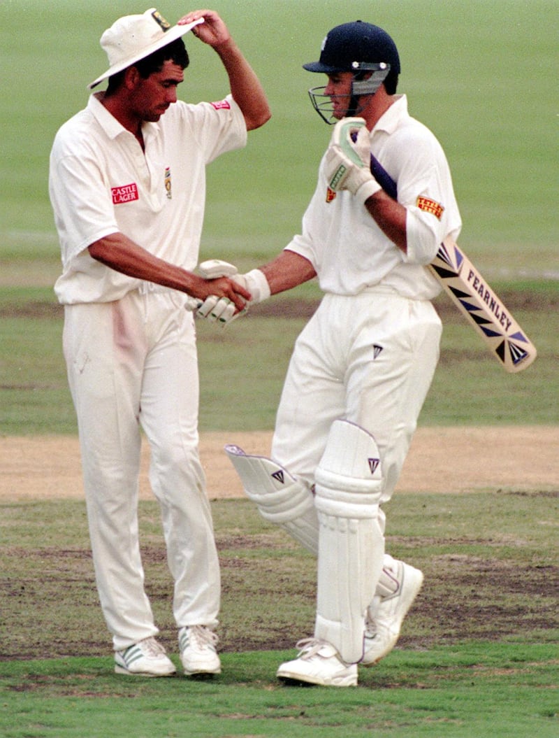 The South African captain Hansie Cronje congratulates Graeme Hick on achieving his 100 as the players leave the field after the England batsmen accepted the bad light offered by the umpires at the close of play  on the 1st day of the Test at Pretoria.   (Photo by Rebecca Naden - PA Images/PA Images via Getty Images)