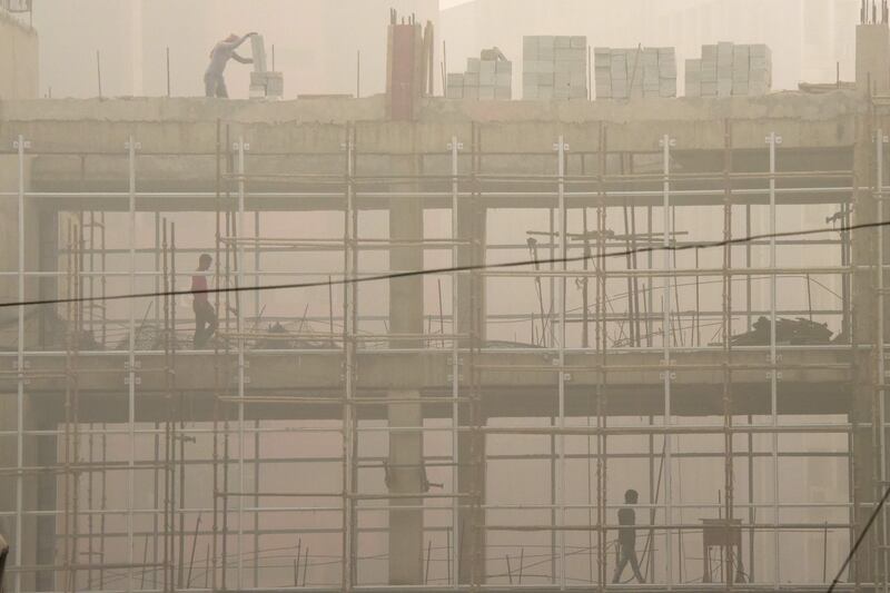 Indian labourers work on a construction site during smoggy weather in New Delhi. Dominique Faget / AFP Photo