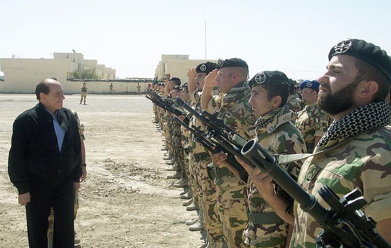 Italian Prime Minister Silvio Berlusconi reviews a detachment of Italian soldiers in Nasiriyah, Iraq, in April 2004 during a surprise visit to Italian troops.  AFP