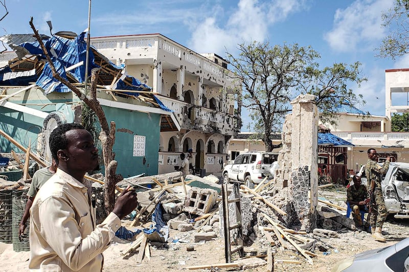 A man passes in front of the rubble of the popular Medina hotel of Kismayo. AFP