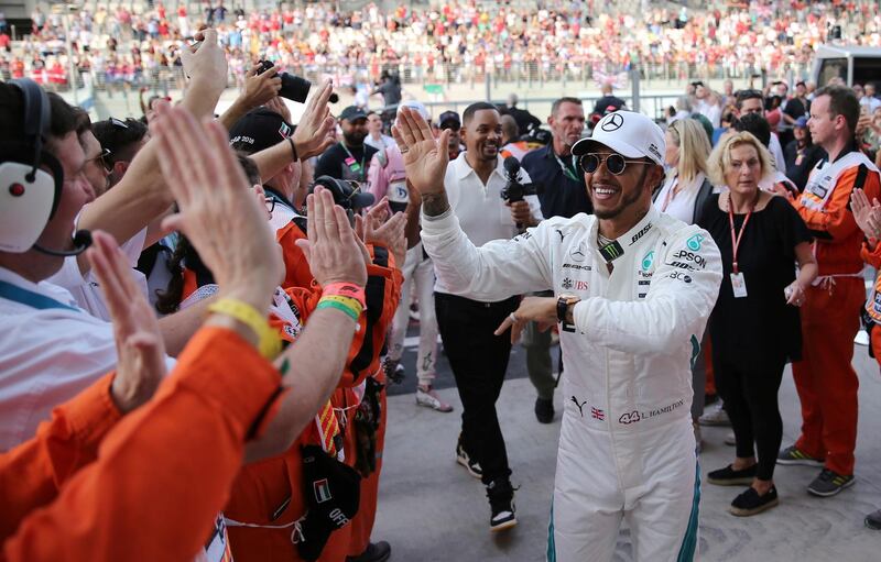 Mercedes driver Lewis Hamilton of Britain cheers with marshalls, followed by US actor Will Smith, prior to the start of the Grand Prix. AP