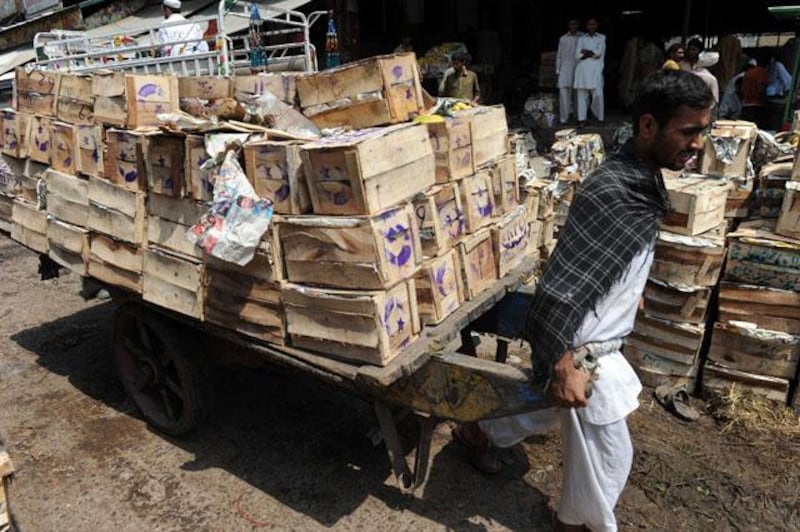 A Pakistani labourer pulls a cart loaded with mango crates at a fruit market ahead of the Islamic holy month of Ramadan in Islamabad on July 8, 2013. Islam's holy month of Ramadan is celebrated by Muslims worldwide marked by fasting, abstaining from foods, sex and smoking from dawn to dusk for soul cleansing and strengthening the spiritual bond between them and the Almighty. AFP PHOTO / AAMIR QURESHI

