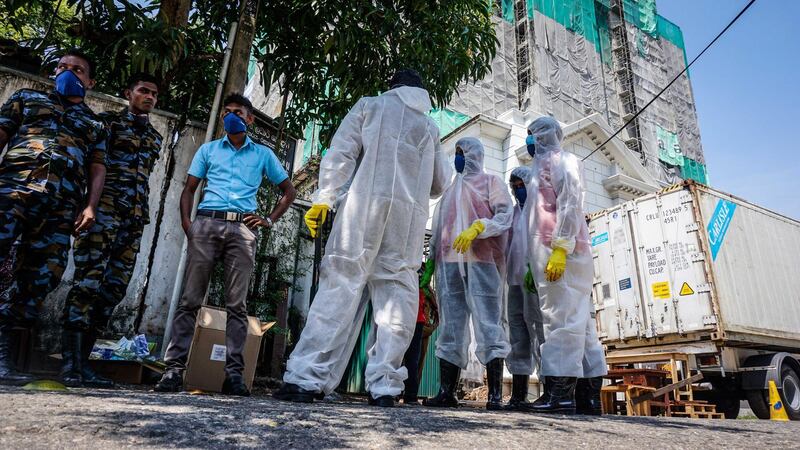 Mortuary workers stand alongside security forces and a truck freezer filled with victims’ bodies in Colombo, Sri Lanka, April 24, 2019. Jack Moore / The National