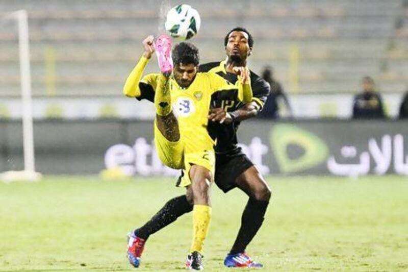 Rashed Essa (in yellow) fights for the ball with Joher Musabeh Obaid from Kalba at Zabeel Stadium.