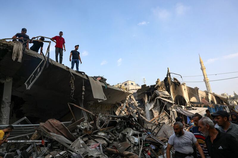 A group of men survey the destruction following air strikes on Al Shatee camp in Gaza city, as Israeli forces entered the northern area of the Gaza Strip. AFP