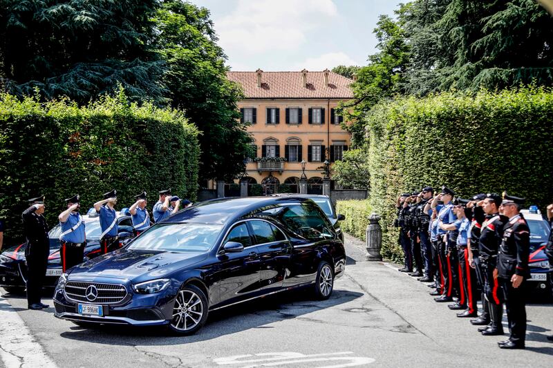 Italian Carabinieri officers salute as the hearse transporting Mr Berlusconi's coffin leaves Villa San Martino. EPA