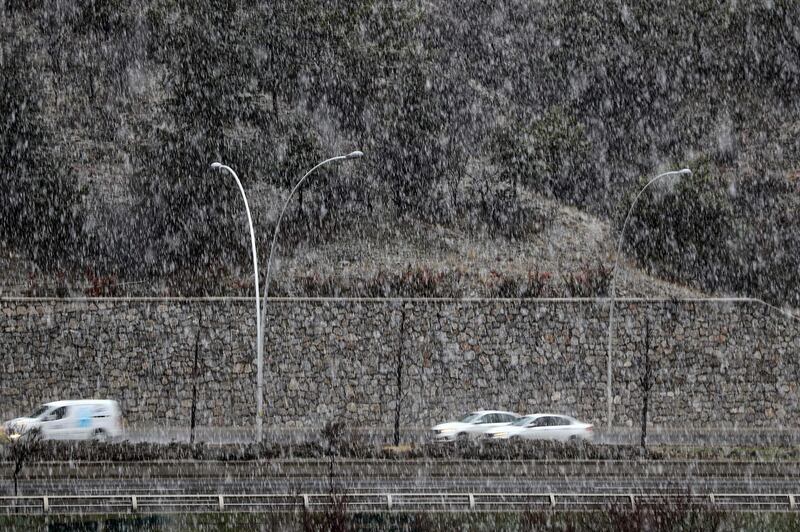 Vehicles drive on a road during heavy snowfall in Ankara.  AFP