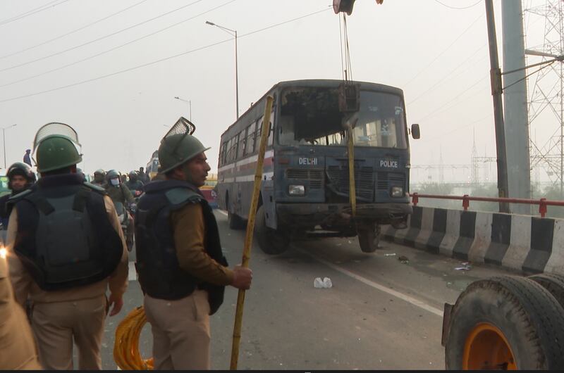 Police lift a vehicle to barricade a motorway at Ghazipur near New Delhi. AP
