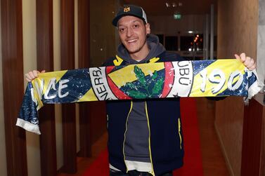 This handout picture taken and released by the Fenerbahce.org on January 18, 2021 in Istanbul shows German midfielder Mesut Ozil posing with a Fenerbahce SK scarf upon his arrival at Ataturk International Airport. Mesut Ozil confirmed on Sunday that he was leaving Arsenal for Turkish team Fenerbahce after being frozen out for months at the Gunners. - RESTRICTED TO EDITORIAL USE - MANDATORY CREDIT "AFP PHOTO / Fenerbahce.org" - NO MARKETING - NO ADVERTISING CAMPAIGNS - DISTRIBUTED AS A SERVICE TO CLIENTS / AFP / Fenerbahce.org / - / RESTRICTED TO EDITORIAL USE - MANDATORY CREDIT "AFP PHOTO / Fenerbahce.org" - NO MARKETING - NO ADVERTISING CAMPAIGNS - DISTRIBUTED AS A SERVICE TO CLIENTS