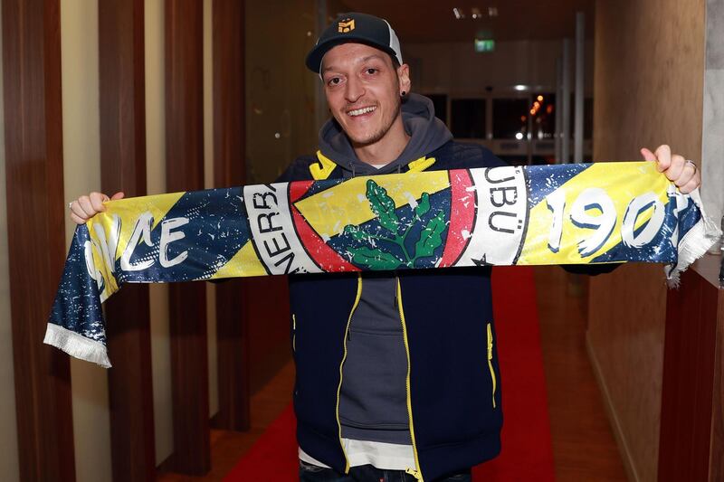This handout picture taken and released by the Fenerbahce.org on January 18, 2021 in Istanbul shows German midfielder Mesut Ozil posing with a Fenerbahce SK scarf upon his arrival at Ataturk International Airport. Mesut Ozil confirmed on Sunday that he was leaving Arsenal for Turkish team Fenerbahce after being frozen out for months at the Gunners. - RESTRICTED TO EDITORIAL USE - MANDATORY CREDIT "AFP PHOTO / Fenerbahce.org" - NO MARKETING - NO ADVERTISING CAMPAIGNS - DISTRIBUTED AS A SERVICE TO CLIENTS
 / AFP / Fenerbahce.org / - / RESTRICTED TO EDITORIAL USE - MANDATORY CREDIT "AFP PHOTO / Fenerbahce.org" - NO MARKETING - NO ADVERTISING CAMPAIGNS - DISTRIBUTED AS A SERVICE TO CLIENTS
