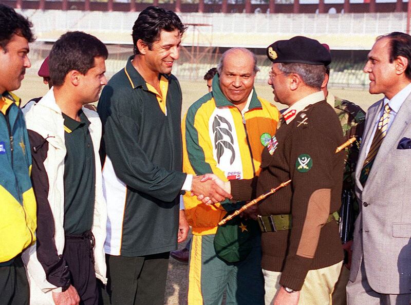 Mr Musharraf shakes hands with Pakistan's cricket team captain Wasim Akram in Lahore on December 24, 1999. AFP