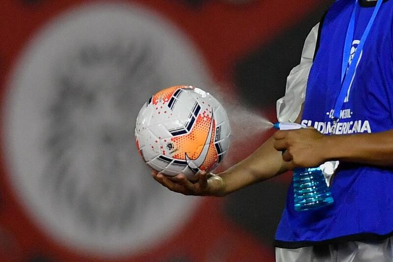 A man disinfects a ball before a closed-door Copa Sudamericana second round football match between Venezuela's Caracas and Brazil's Vasco da Gama at the Olympic Stadium in Caracas. AFP