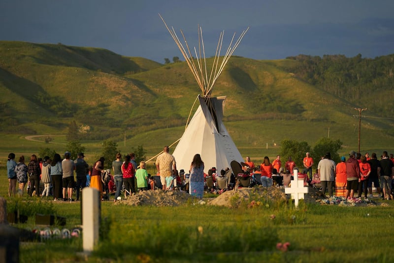 Hundreds of people gather for a vigil in a field where human remains were discovered in unmarked graves at the site of a former residential school in Saskatchewan, Canada. More than 750 unmarked graves have been found near a former Catholic boarding school for indigenous children in western Canada, a tribal leader said -- the second such shock discovery in less than a month. AFP
