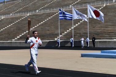 ATHENS, GREECE - MARCH 12: An Athlete carries the Olympic torch during the Flame Handover Ceremony for the Tokyo 2020 Summer Olympics on March 19, 2020 in Athens, Greece. The ceremony was held behind closed doors as a preventive measure against the Coronavirus outbreak. (Photo by Aris Messinis - Pool/Getty Images Europe)