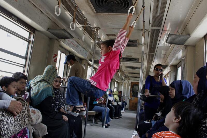 A girl uses hand grips to swing inside a female-only metro car, in Cairo, Egypt.