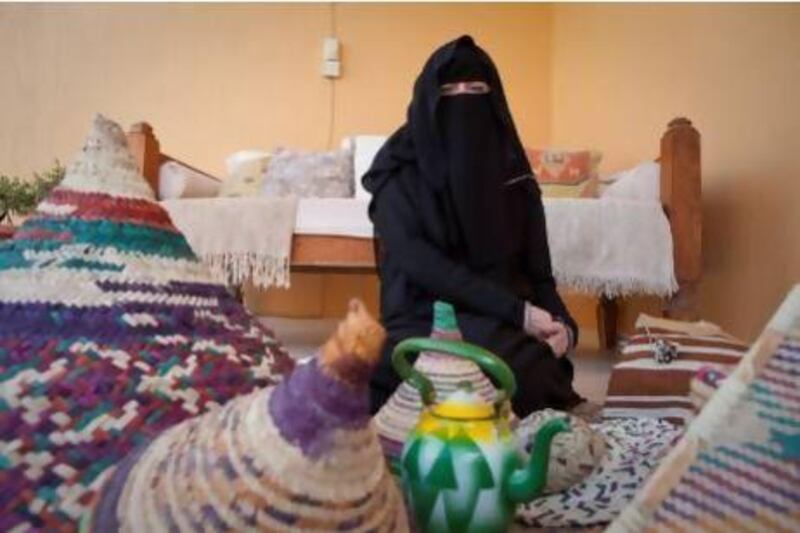 Amal Loring, a cross-cultural consultant for business professionals, poses with examples of handicrafts made by Emirati women. Razan Alzayani / The National