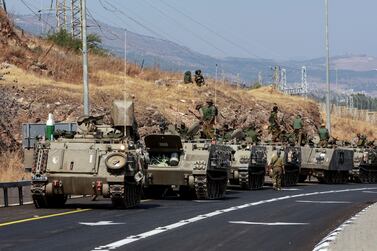 A convoy of Israeli Armoured Personnel Carriers (APCs) drives on a road near Israel's border with Lebanon, northern Israel, October 9, 2023.  REUTERS / Ammar Awad