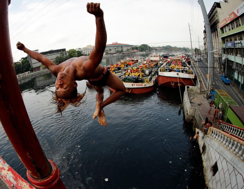 Filipino children jump into the polluted waters of Pasig river in Manila. Francis R Malasig / EPA