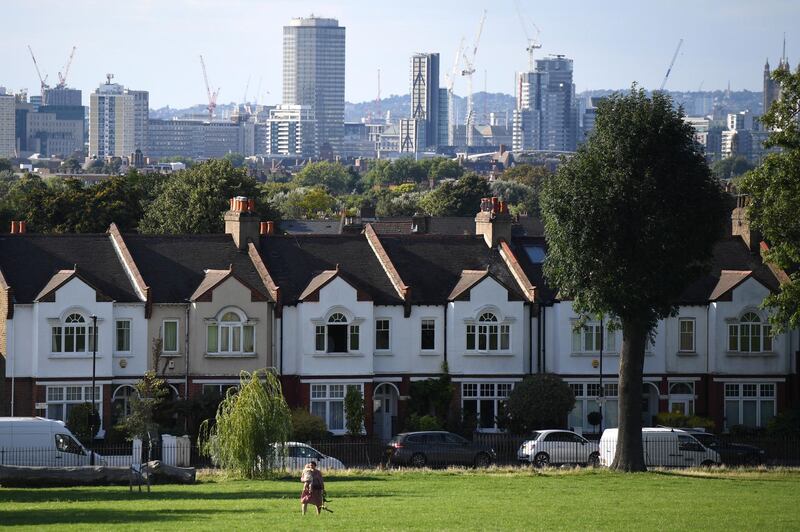 A woman walks newar a row of houses in London on August 13, 2017.
The average price of a house in the UK increased by 4.9% in the year to June, according to figures released on Auguest 15 by the Office for National Statistics (ONS).  / AFP PHOTO / Chris J Ratcliffe