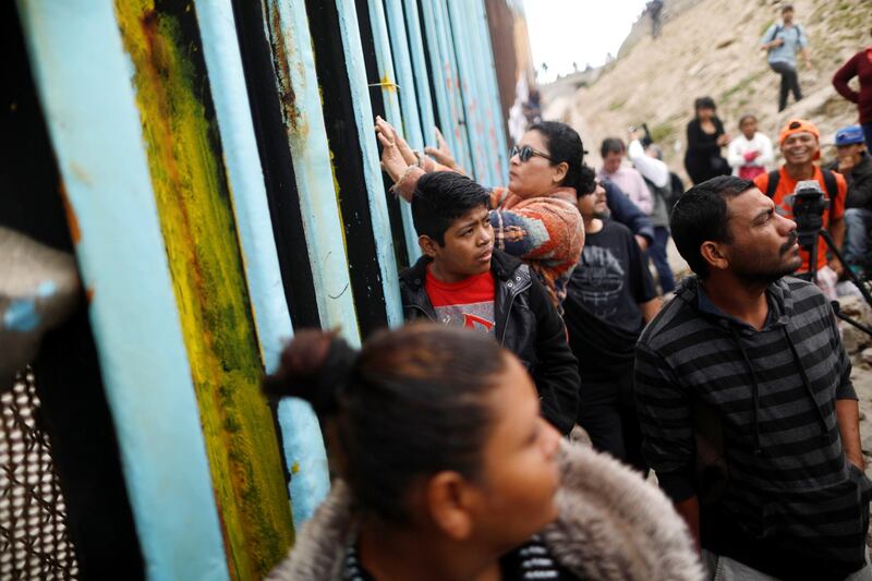 Members of a caravan of migrants from Central America gather at the border fence between Mexico and the U.S. as part of a demonstration, prior to preparations for an asylum request in the U.S., in Tijuana, Mexico April 29, 2018. REUTERS/Edgard Garrido