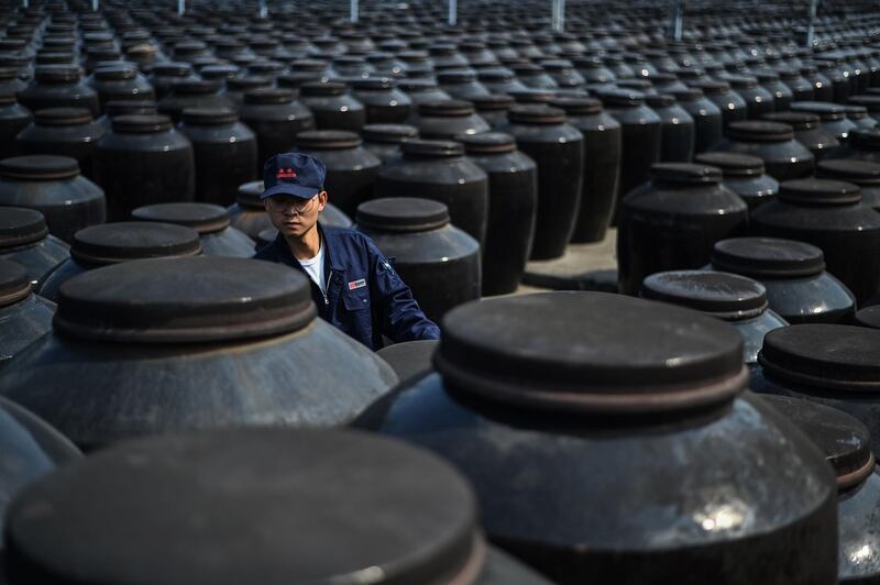 A worker checks rice vinegar stored in large jars at a plant in Zhenjiang, in China's eastern Jiangsu province. Hector Retamal/ AFP