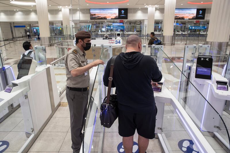 A passenger passes through a smart gate at Dubai International Airport. 
