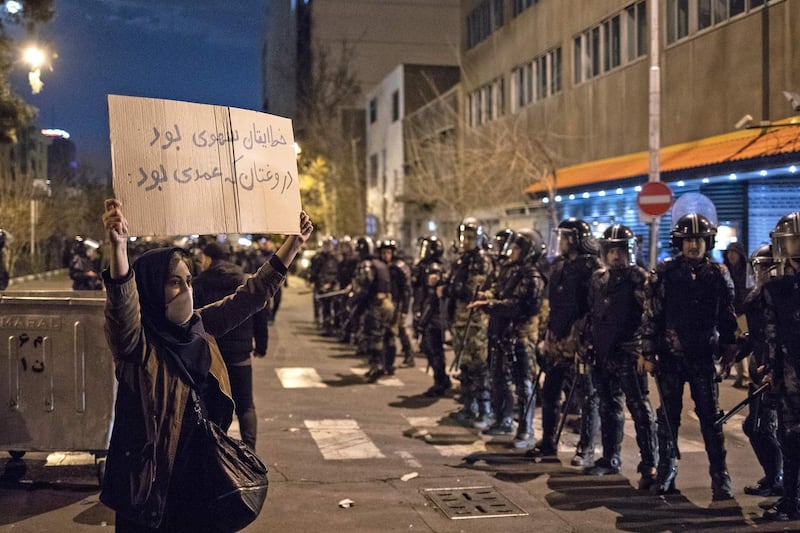 An Iranian woman holds a placard reading in Farsi "Your mistake was unintentional, your lie was intentional" during a demonstration outside Tehran's Amir Kabir University.  AFP