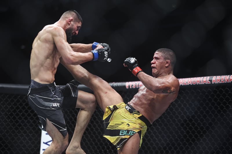 Gilbert Burns lands a kick on Khamzat Chimaev during their welterweight bout at UFC 273. Getty