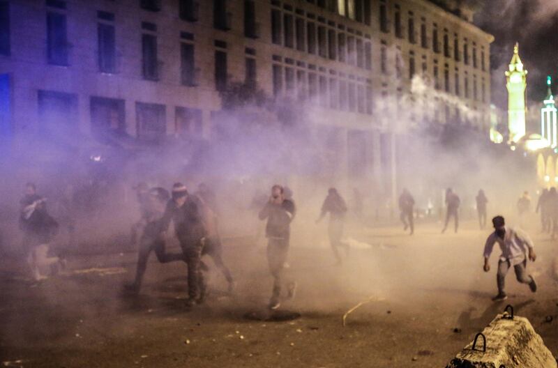 Protesters flee gas grenades after they threw stones at riot police during clashes in central Beirut, Lebanon.  EPA