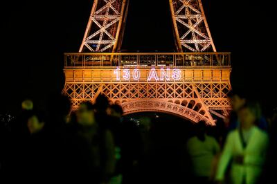 A picture taken on May 15, 2019 shows the inscription "130 years" displayed on the Eiffel Tower during a light show celebrating the 130th anniversary of its construction, in Paris. Built for the 1889 World's Fair, towering at 324 meters and weighing 7300 tons, the Eiffel Tower attracts nearly seven million visitors every year. / AFP / Zakaria ABDELKAFI
