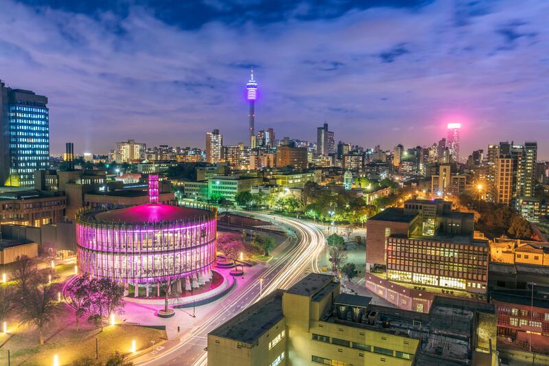 Johannesburg cityscape, taken at sunset, showing the illuminated Council Chamber which is set to be the centre for the revitalisation and urban renewal of the precinct. Hillbrow residential area and the prominent communications tower and Ponte flats.