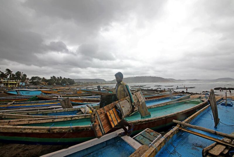 A fisherman carries his tools as he leaves for a safer place after tying his boats along the shore as a cyclone approaches Peda Jalaripeta on the outskirts of Visakhapatnam. Reuters