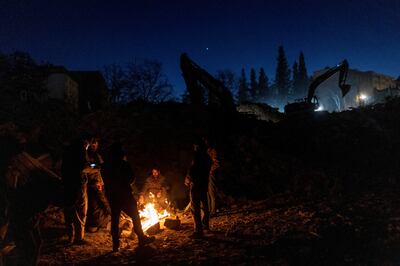 Earthquake survivors gather around a fire in Kahramanmaras, southern Turkey. Reuters
