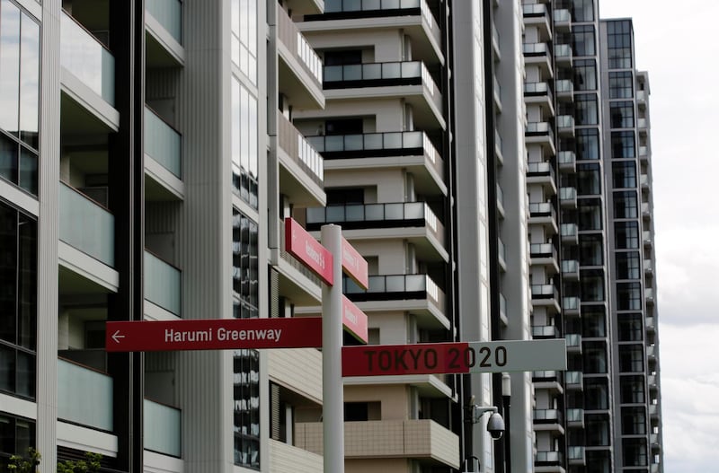 Residential buildings are seen behind road signs at the Tokyo 2020 Olympic and Paralympic Village in Tokyo.