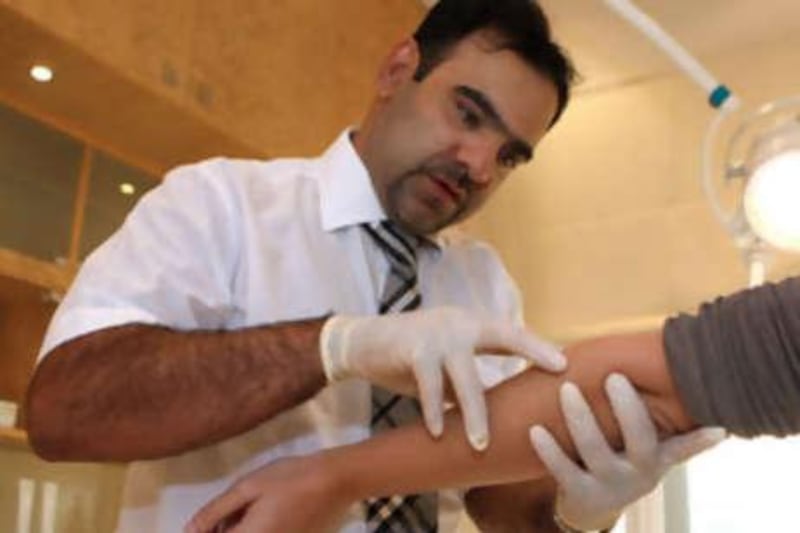 Dr Ali Singel checks the arm of Sophia Money-Coutts for patches of vitiligo at the Dermalase clinic in Dubai.