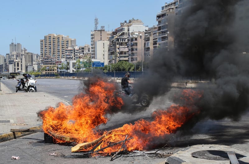 epa09279339 A roadblock made of garbage bins and burning tires during a general strike, in Beirut, Lebanon, 17 June 2021. The strike was called by the General Labor Union in all Lebanese governorates to protest against the countryâ€™s political and economic crisis amid constant power cuts, the high cost of living and the low purchasing power of the Lebanese pound, as well as the failure of political leaders to form a government after months of deadlock.  EPA/NABIL MOUNZER