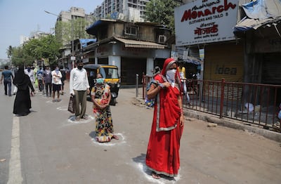 Indians stand in marked positions to buy essential commodities from a grocery store in Mumbai, India, Wednesday, March 25, 2020.The world's largest democracy went under the world's biggest lockdown Wednesday, with India's 1.3 billion people ordered to stay home in a bid to stop the coronavirus pandemic from spreading and overwhelming its fragile health care system as it has done elsewhere. For most people, the new coronavirus causes mild or moderate symptoms, such as fever and cough that clear up in two to three weeks. For some, especially older adults and people with existing health problems, it can cause more severe illness, including pneumonia and death.(AP Photo/Rafiq Maqbool)