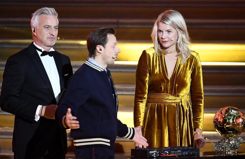 Ada Hegerberg (R) looks on next to French former player and presenter David Ginola and French DJ and co-host Martin Solveig (C) after receiving the women's 2018 FIFA Women's Ballon d'Or award. AFP