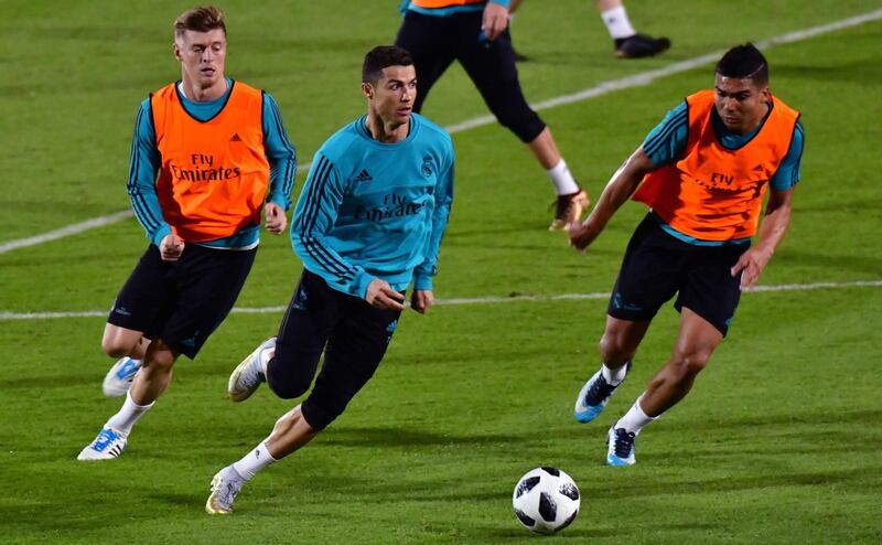 Real Madrid's Portuguese forward Cristiano Ronaldo runs with the ball during a training session two days prior to his team's FIFA Club World Cup semi-final match at New York University Abu Dhabi's stadium in the Emirati capital on December 11, 2017. / AFP PHOTO / GIUSEPPE CACACE