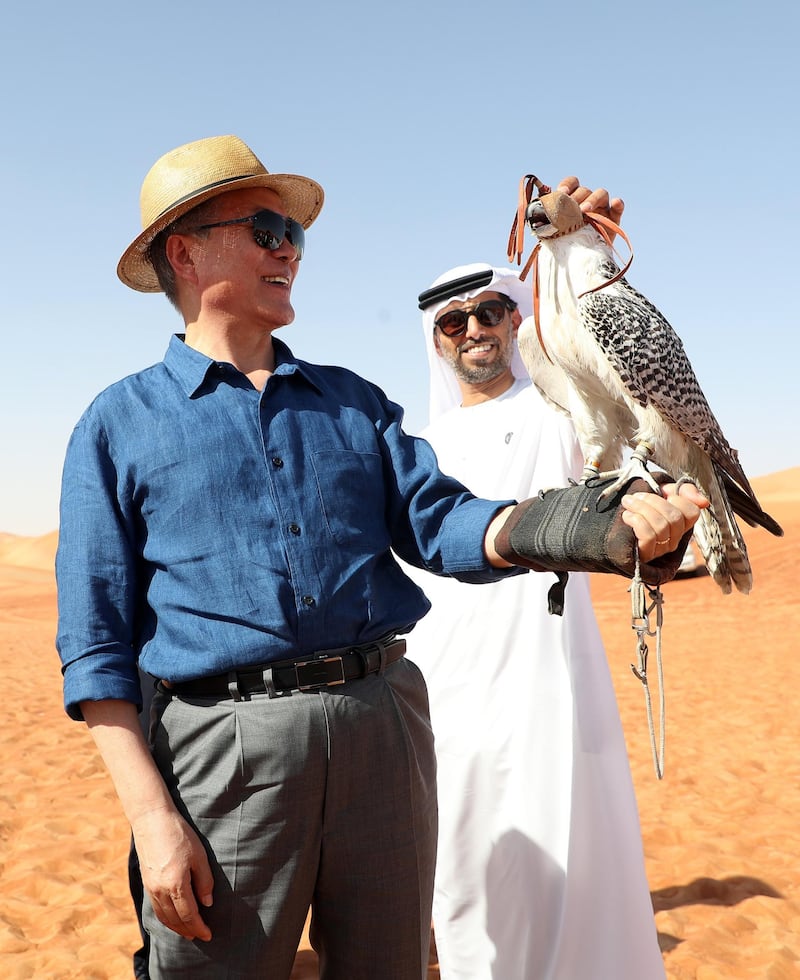 epaselect epa06631492 A falcon perches on the arm of South Korean President Moon Jae-in (L) during his visit to a desert near Abu Dhabi, United Arab Emirates, 26 March 2018 (issued 27 March 2018). The brief trip 170 km from Abu Dhabi was arranged impromptu by Crown Prince of Abu Dhabi Mohammed bin Zayed Al-Nahyan, who was told of Moon's wish to experience the desert and provided helicopters and vehicles.  EPA/YONHAP SOUTH KOREA OUT