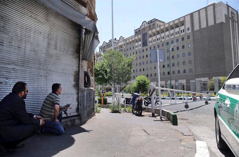 FILE - In this June 7, 2017, file photo, security personnel take position in front of Iran's parliament building after an assault of several attackers, in Tehran, Iran. Iran said Saturday, July 7, 2018, it executed eight people convicted in the 2017 Islamic State group attack on parliament and the shrine of Ayatollah Ruhollah Khomeini in Tehran. (Omid Vahabzadeh/Fars News Agency via AP, File)