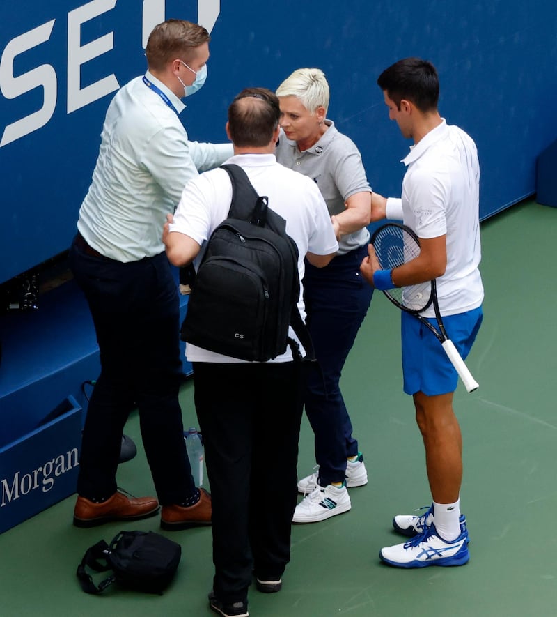 Novak Djokovic tries to help  the line judge. EPA