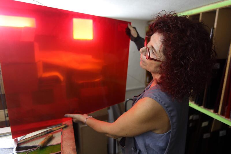 Husseini examines red glass to be used on one of her artworks in progress.