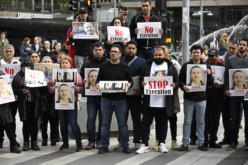 Demonstrators hold posters of Ahmadreza Jalali during a protest to free him, in Stockholm, Sweden. AFP