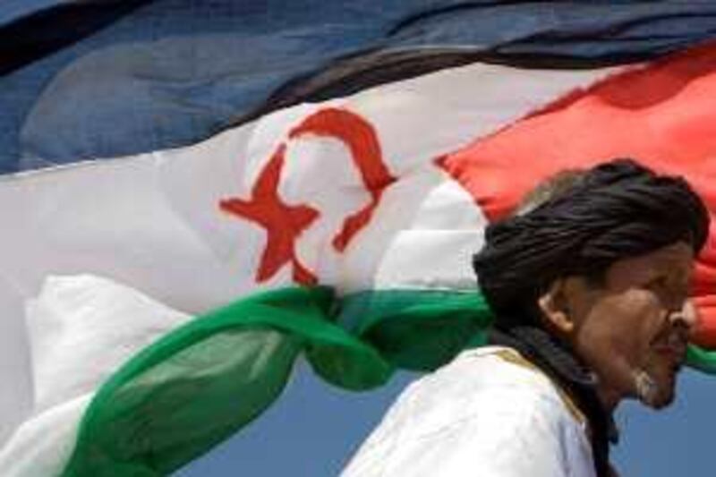Pro-independence Polisario Front supporter looks on during a military parade as a Western Sahara flag flys in the breeze, in the village of Tifariti,  Tuesday May 19, 2008, to celebrate the 35th anniversary of the Polisario Army. After Spanish colonizers left Western Sahara in 1975, Morocco and Mauritania went to war over it. By 1979, Mauritania had pulled out and Morocco had taken over. But fighting continued between 15,000 Saharaui's Polisario guerrillas and Morocco's U.S. equipped army. A U.N. negotiated truce in 1991 called for a referendum on the region's future, but that vote never happened. (AP Photo/Daniel Ochoa de Olza)