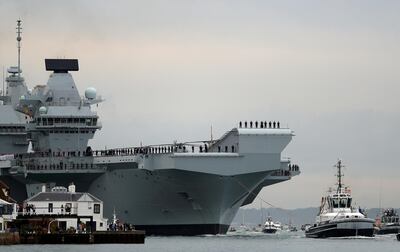 FILE PHOTO: Royal Navy aircraft carrier, HMS Queen Elizabeth, is towed by tugs as it arrives at Portsmouth Naval base, Britain August 16, 2017.   REUTERS/Peter Nicholls/File Photo