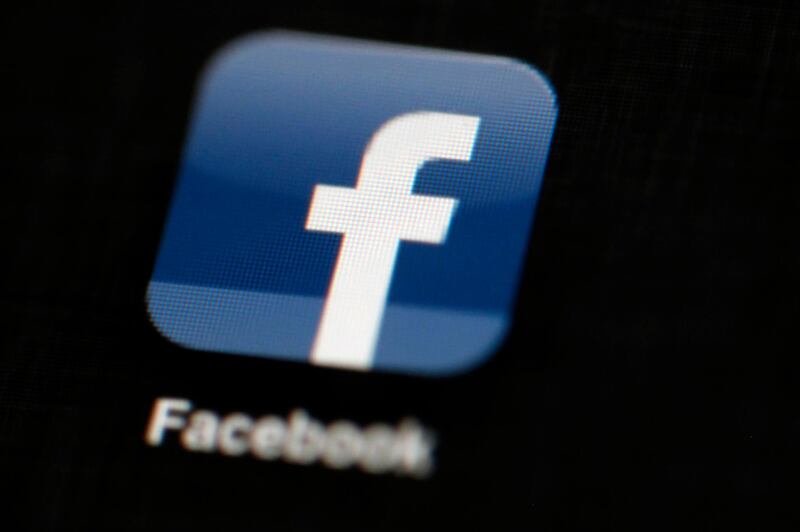 FILE - In this May 16, 2012, file photo, the Facebook logo is displayed on an iPad in Philadelphia.  Facebook suspended Cambridge Analytica, a data-analysis firm that worked for President Donald Trump's 2016 campaign, over allegations that it held onto improperly obtained user data after telling Facebook it had deleted the information.  (AP Photo/Matt Rourke, File)