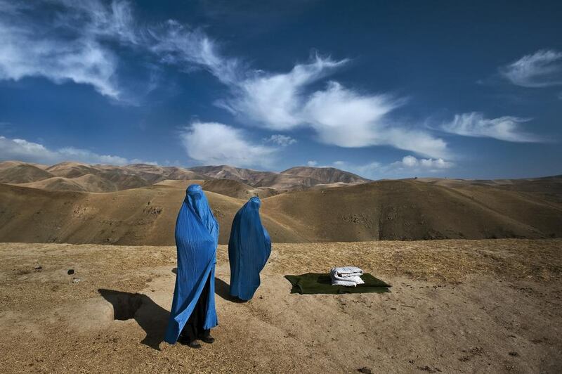 Two women walk along road in burquas. Courtesy Lynsey Addario